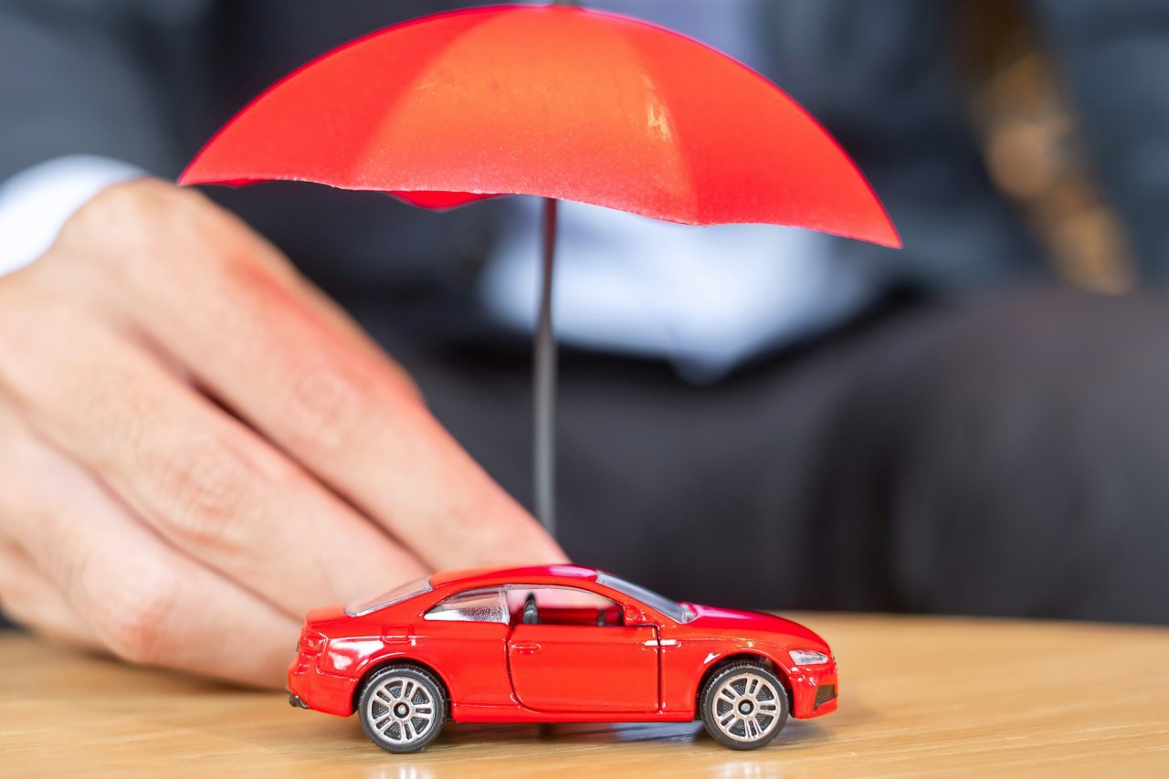 General Insurance Products 10 businessman hand holding umbrella cover or protection red car toy on table car insurance concept